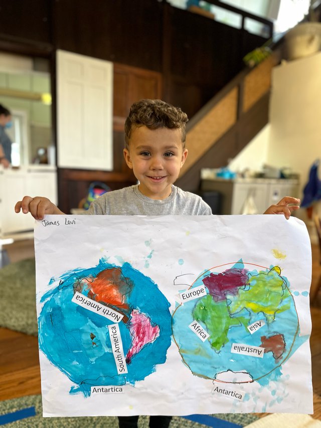 Child concentrating on watercolor painting, developing artistic skills and creative expression in Montessori art program